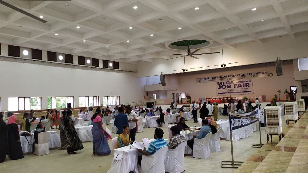 Interview stations filled with candidates at a Mega Job Fair college auditorium